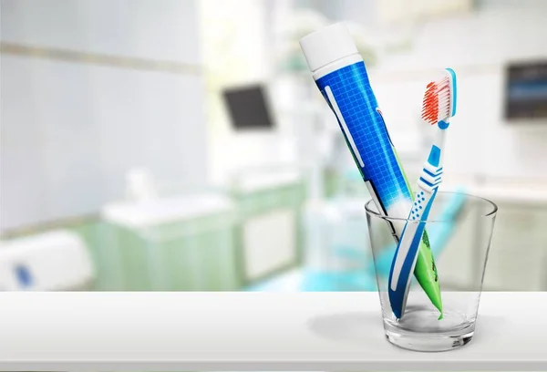 Toothbrush and toothpaste in glass — Stock Photo, Image