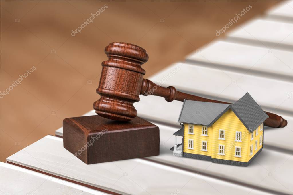 Wooden judge gavel and house on table 