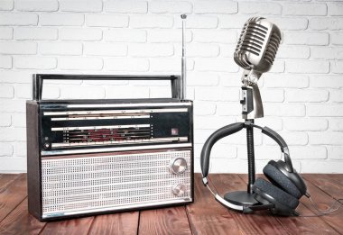 Mikrofon, radyo ve ahşap masa üzerinde kulaklık 