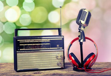 Mikrofon, radyo ve ahşap masa üzerinde kulaklık 