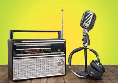Mikrofon, radyo ve ahşap masa üzerinde kulaklık 