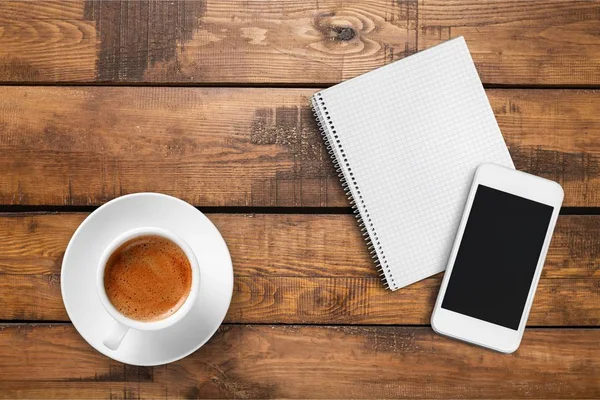Смартфон с ноутбуком и чашкой кофе — стоковое фото