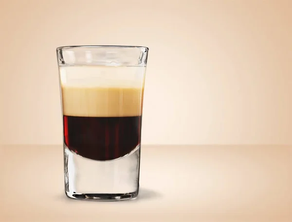 Glass of layered cocktail isolated on background