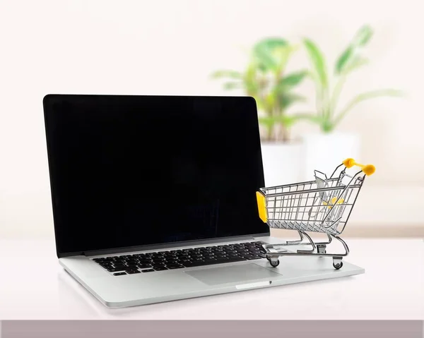 Laptop e carrinho de compras — Fotografia de Stock