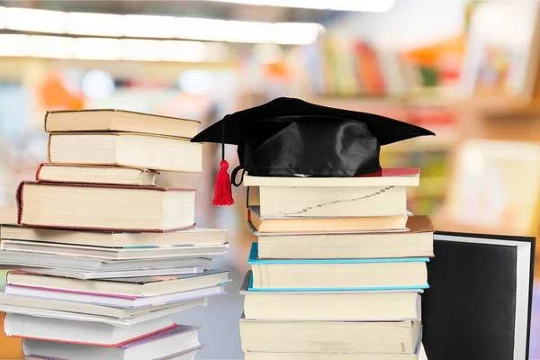 Sombrero de graduación en la pila de libros — Foto de Stock