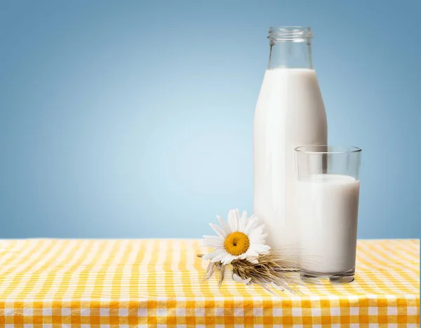 Milk in glass and bottle on wooden table