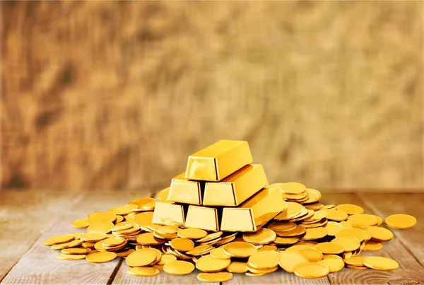 金の延べ棒と木製のテーブル上のコイン — ストック写真