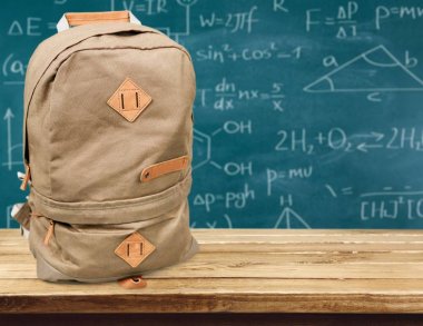 Ahşap masa üzerinde okul sırt çantası 