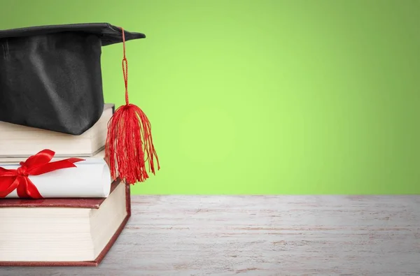 Sombrero de graduación en la pila de libros — Foto de Stock