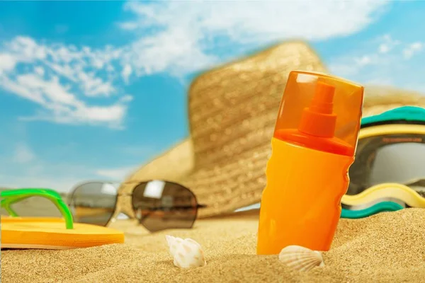 Bottles of sunscreen lotion on beach background