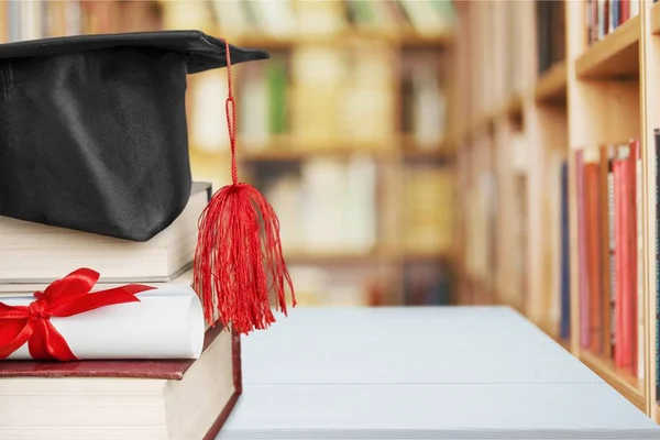 Sombrero de graduación en la pila de libros — Foto de Stock