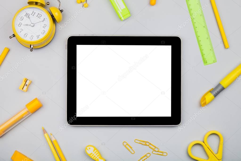Modern digital tablet with yellow clock and pen isolated on grey background