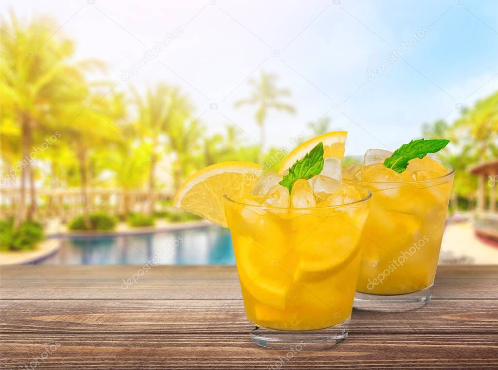 glasses with cocktails with lemon on blurred background