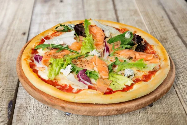サーモンの木製の背景に分離されたおいしいピザ — ストック写真
