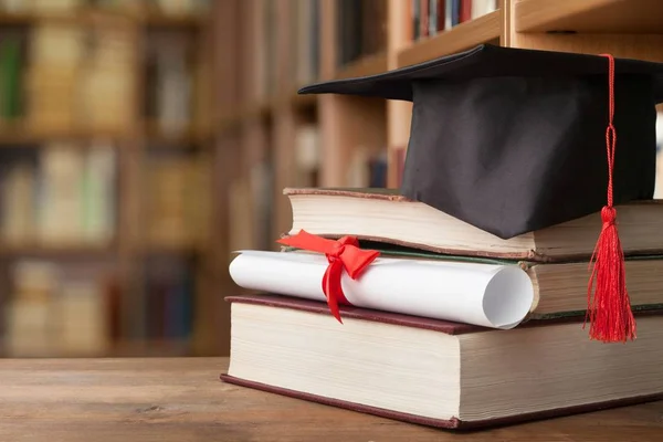 Sombrero de graduación en la pila de libros — Foto de Stock