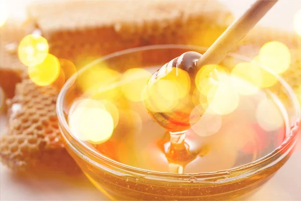 Honey dipper and glass bowl — Stock Photo, Image