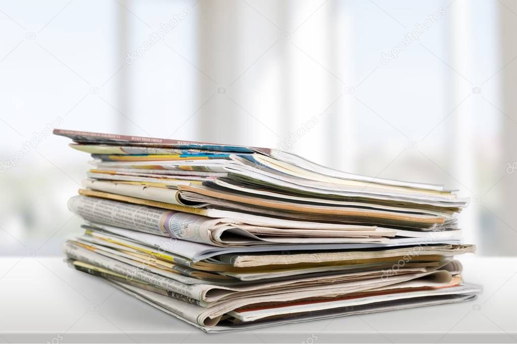 Pile of printed newspapers on light background 