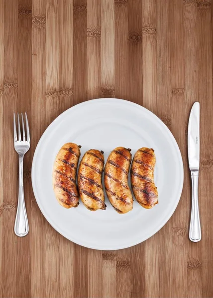 tasty grilled sausages on plate background