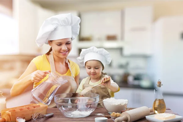 Meisje en haar moeder samen bakken — Stockfoto