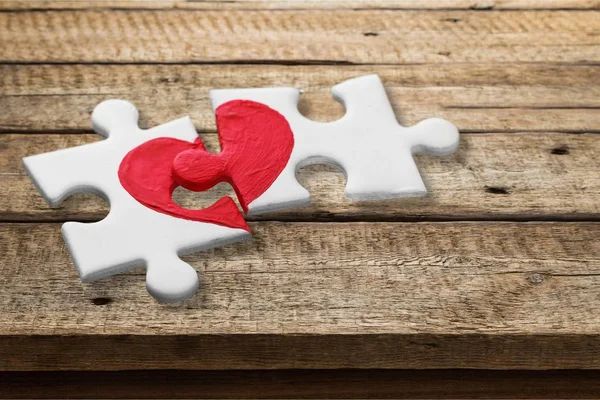 Pezzi Puzzle Con Cuore Rosso Dipinto Sfondo Legno — Foto Stock