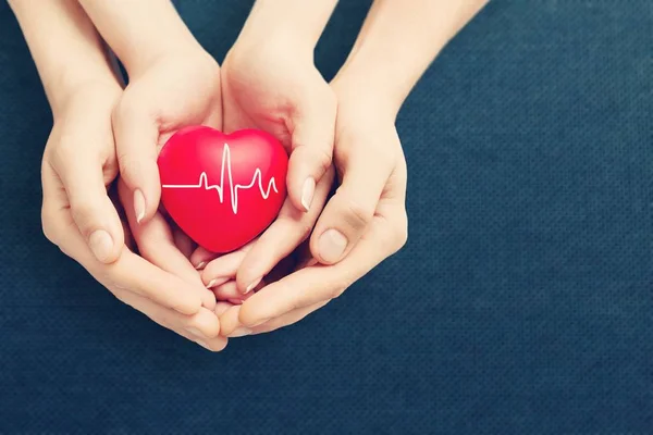 Man and woman holding red heart — Stock Photo, Image