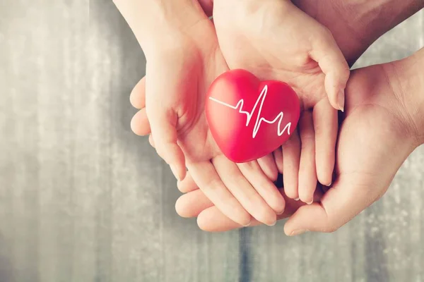 Hombre y mujer sosteniendo el corazón rojo —  Fotos de Stock