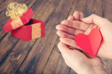 Close-up red Heart in female hands, love concept clipart