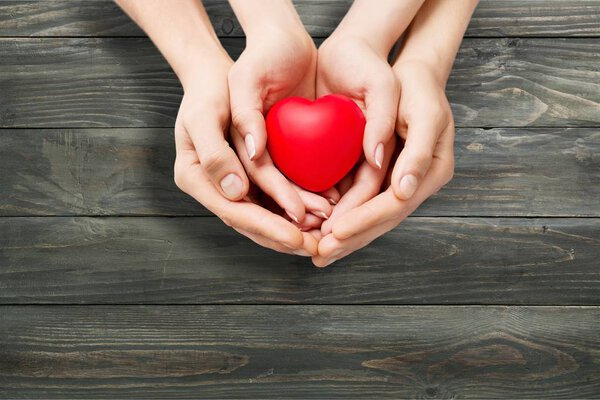 Man and woman holding red heart 