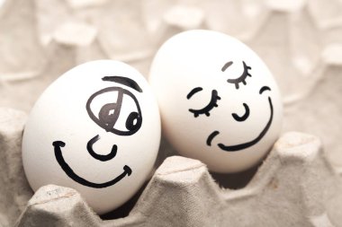 bir paket içinde farklı yüzlerle beyaz yumurta