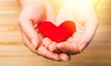Ellerinde arka plan üzerinde kırmızı kalp 