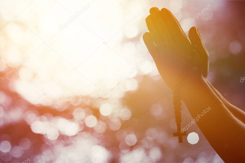 Hands of human praying on blurred background 