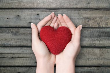Ellerinde arka plan üzerinde kırmızı kalp 