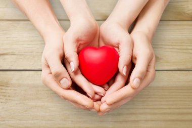 Adam ve arka plan üzerinde kırmızı kalp tutan kadın 