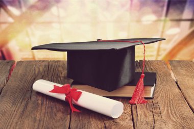 Mezuniyet şapka, kitap ve diploma masada