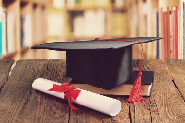 Mezuniyet şapka, kitap ve diploma masada