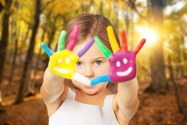 Little girl showing painted hands — Stock Photo, Image