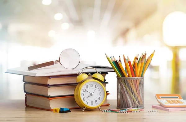 Stack of colorful notebooks, stationery and pencils