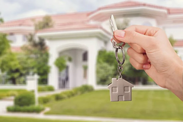 Home key in hand on blurred background