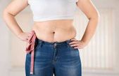 tlustá žena měří svůj žaludek