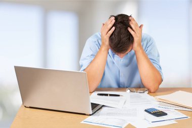 Bir yığın evrakı olan genç iş adamı.