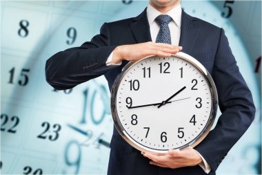 Saat arka plan bulanık ellerinde tutan işadamı 