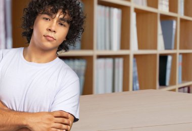 kütüphanede poz kıvırcık saçlı genç adam 