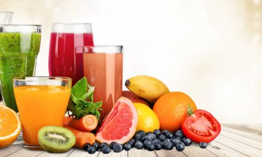 yakın çekim gözlük ile çeşitli meyve ve sebze arka plan üzerine taze meyve suyu