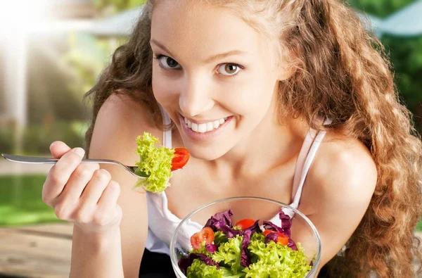 Mujer sosteniendo ensalada y sonriendo — Foto de Stock