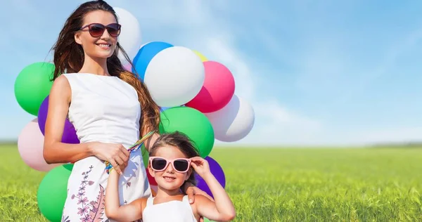 Matka s dcerou hospodářství barevné balónky — Stock fotografie