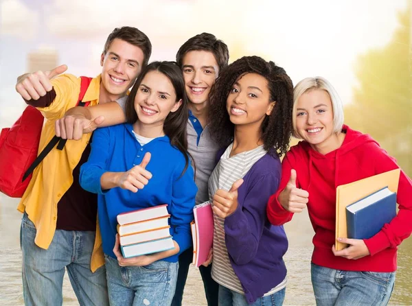 Jóvenes estudiantes señalando pulgares hacia arriba — Foto de Stock