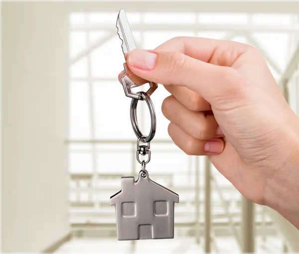 Home key in hand on blurred background