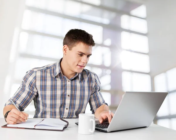 Jovem feliz trabalha em seu laptop — Fotografia de Stock