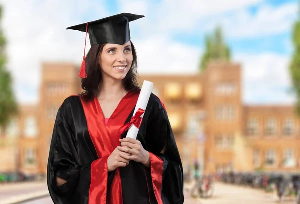 Beautiful female graduation student with paper — Stock Photo, Image