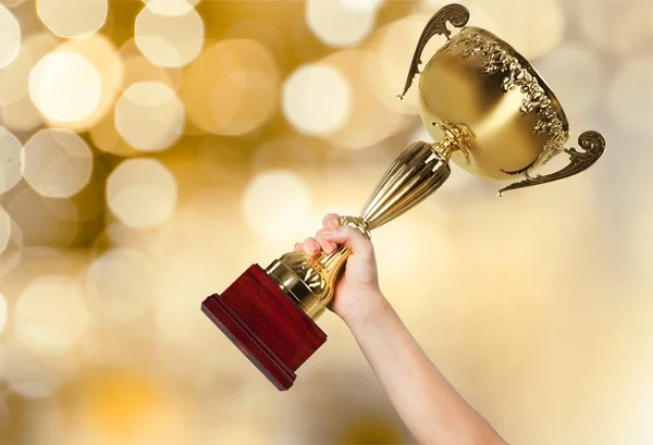 Mão Segurando Troféu Dourado Fundo Embaçado — Fotografia de Stock